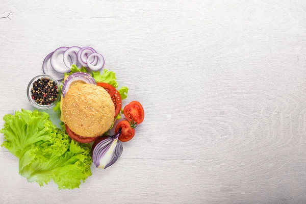 Peynir, et, domates ve soğan ve otlar ile hamburger. Ahşap arka plan üzerinde. Üstten Görünüm. Boş alan.