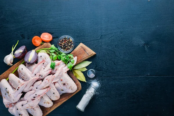 Baharat ile çiğ tavuk kanatları. Ahşap yüzeyde. Üstten Görünüm.