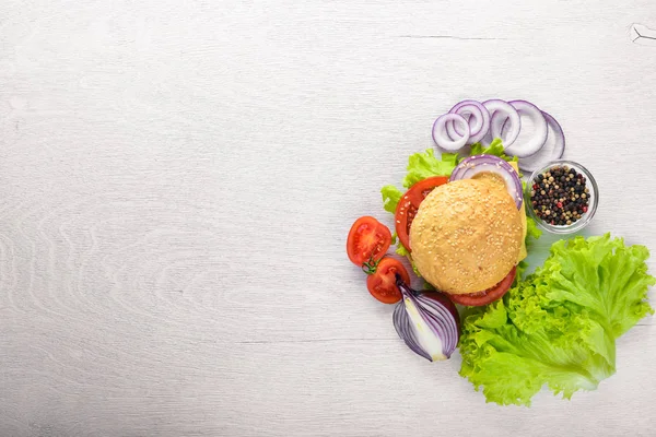 Peynir, et, domates ve soğan ve otlar ile hamburger. Ahşap arka plan üzerinde. Üstten Görünüm. Boş alan.