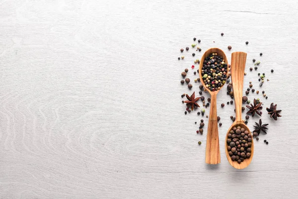 A set of fragrant spices. A mixture of black and red pepper, coriander, paprika. On Wooden background. Top view. Free space.