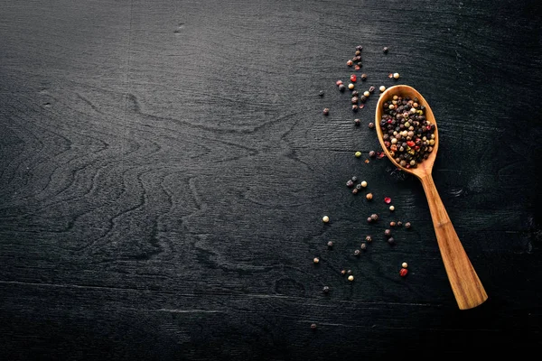 Güzel kokulu baharatlar kümesi. Siyah ve kırmızı biber, kişniş, kırmızı biber karışımı. Ahşap arka plan üzerinde. Üstten Görünüm. Boş alan.