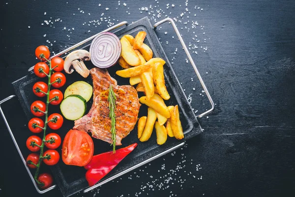 Biftek, patates ve taze sebze. Ahşap bir arka plan üzerinde. Üstten Görünüm. Metniniz için boş alan.