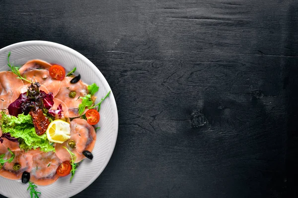 Carpaccio balık, sebze, peynir, baharatlar, ahşap arka plan için. Üstten Görünüm. Boş alan.