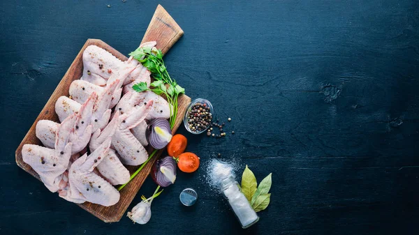 Baharat ile çiğ tavuk kanatları. Ahşap yüzeyde. Üstten Görünüm.