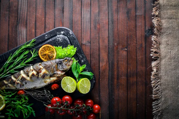 Forellenfisch gebacken mit aromatischen Kräutern und Gewürzen. auf Holzgrund. — Stockfoto