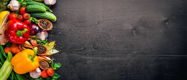 Frame of organic food. Fresh raw vegetables and spices. On a wooden chalkboard.