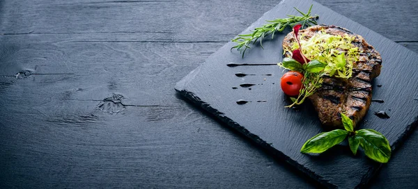 Dana biftek ızgarada pişirilir. Ahşap bir arka plan üzerinde. En iyi bir daha gözden geçirme. Boş alan.