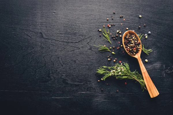 Güzel kokulu baharatlar kümesi. Siyah ve kırmızı biber, kişniş, kırmızı biber karışımı. Ahşap arka plan üzerinde. Üstten Görünüm. Boş alan.