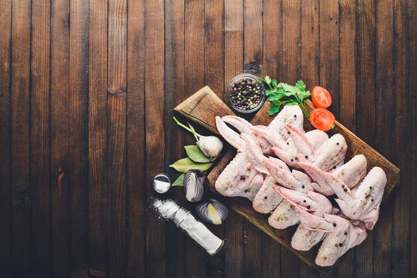 Baharat ile çiğ tavuk kanatları. Ahşap yüzeyde. Üstten Görünüm.