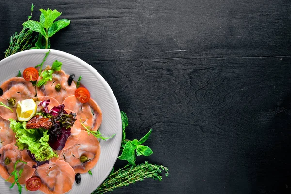 Carpaccio balık, sebze, peynir, baharatlar, ahşap arka plan için. Üstten Görünüm. Boş alan.