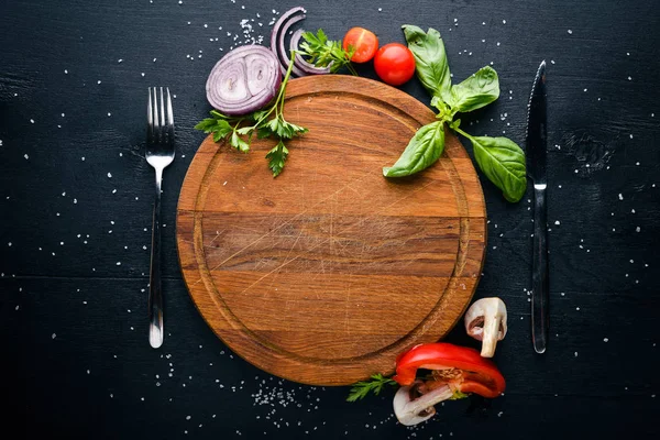 Ahşap köpük taze sebze ve baharatlar ile. Yemek pişirmek için hazırlanıyor. Bir siyah ahşap yüzeye. Metniniz için boş alan. Üstten Görünüm.