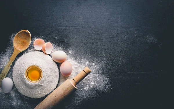 Pişirme için hazırlık. Bir oklava ile yumurta. Taş masanın üstünde. Metin için özgür yer. Üstten Görünüm.