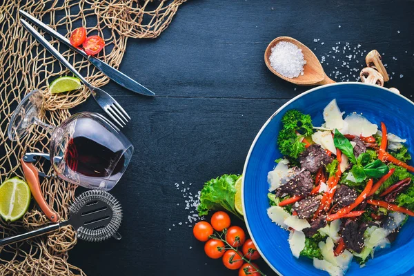 Dana eti ve taze sebze salatası. Ahşap bir arka plan üzerinde. Üstten Görünüm. Metniniz için boş alan.