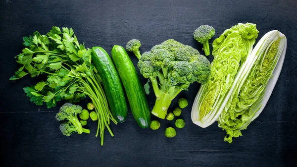 Kara taş üzerine yerleştirilmiş taze yeşil sebze topluluğu