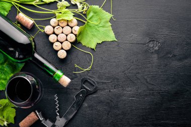 Üzüm cinayet sebebi. Bir şişe, bir bardak şarap ve üzüm yaprakları. Üstten Görünüm. Boş alan.