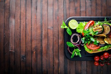 Bruschetta ızgara sebze, zeytin, otlar ve parmesan peyniri ekmeğin. Soğuk aperatifler. İtalyan mutfağı. Ahşap arka plan üzerinde.