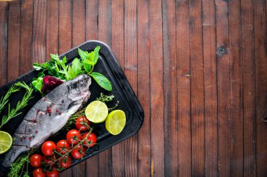 Balık alabalık aromatik otlar ve baharatlar ile. Ahşap arka plan üzerinde.