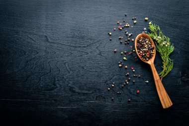 Güzel kokulu baharatlar kümesi. Siyah ve kırmızı biber, kişniş, kırmızı biber karışımı. Ahşap arka plan üzerinde. Üstten Görünüm. Boş alan.