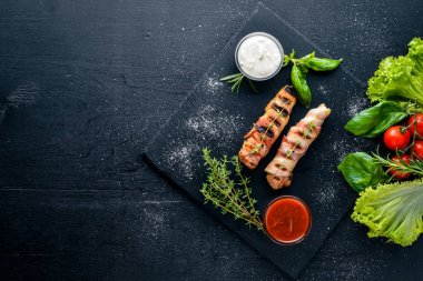 Rulo tavuk fileto ve pastırma. Ahşap bir arka plan üzerinde. En iyi bir daha gözden geçirme. Boş alan.