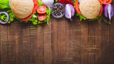 Peynir, et, domates ve soğan ve otlar ile hamburger. Ahşap arka plan üzerinde. Üstten Görünüm. Boş alan.