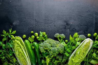 Kara taş üzerine yerleştirilmiş taze yeşil sebze topluluğu