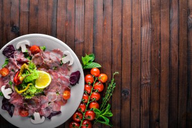 Carpaccio sığır eti, sebze, peynir, baharatlar, ahşap arka plan için. Üstten Görünüm. Boş alan