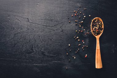 Güzel kokulu baharatlar kümesi. Siyah ve kırmızı biber, kişniş, kırmızı biber karışımı. Ahşap arka plan üzerinde. Üstten Görünüm. Boş alan.