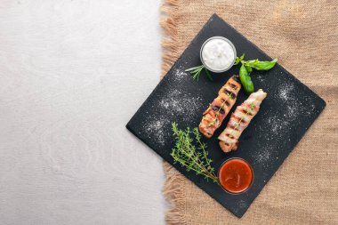 Rulo tavuk fileto ve pastırma. Ahşap bir arka plan üzerinde. En iyi bir daha gözden geçirme. Boş alan.