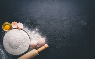 Pişirme için hazırlık. Bir oklava ile yumurta. Taş masanın üstünde. Metin için özgür yer. Üstten Görünüm.