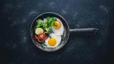 Sahanda yumurta ile bir tavada sebze ve otlar. Üstten Görünüm. Boş alan.