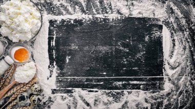 Ekmek, peynir ekşi krema, süt, un, yumurta için hazırlık. Siyah ahşap arka plan üzerinde. Üstten Görünüm. Boş alan.