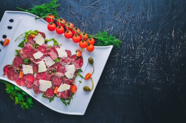 Et ve sebze ile carpaccio. İtalyan mutfağı. Ahşap bir arka plan üzerinde. Üstten Görünüm. Metniniz için boş alan.