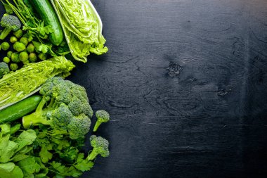 Kara taş üzerine yerleştirilmiş taze yeşil sebze topluluğu