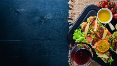 Somon Bruschetta otlar ve parmesan peyniri ekmeğin. Soğuk aperatifler. İtalyan mutfağı. Ahşap arka plan üzerinde.