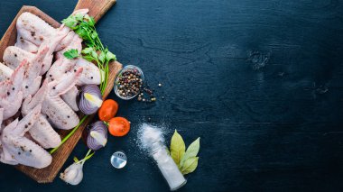 Baharat ile çiğ tavuk kanatları. Ahşap yüzeyde. Üstten Görünüm.