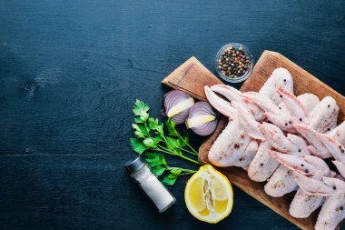 Baharat ile çiğ tavuk kanatları. Ahşap yüzeyde. Üstten Görünüm.