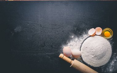 Pişirme için hazırlık. Bir oklava ile yumurta. Taş masanın üstünde. Metin için özgür yer. Üstten Görünüm.