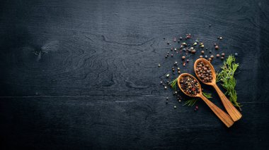 Güzel kokulu baharatlar kümesi. Siyah ve kırmızı biber, kişniş, kırmızı biber karışımı. Ahşap arka plan üzerinde. Üstten Görünüm. Boş alan.