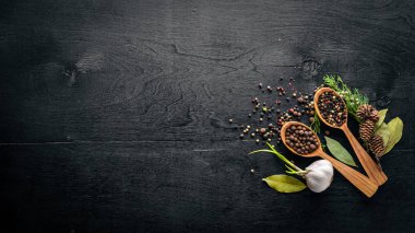 Güzel kokulu baharatlar kümesi. Siyah ve kırmızı biber, kişniş, kırmızı biber karışımı. Ahşap arka plan üzerinde. Üstten Görünüm. Boş alan.