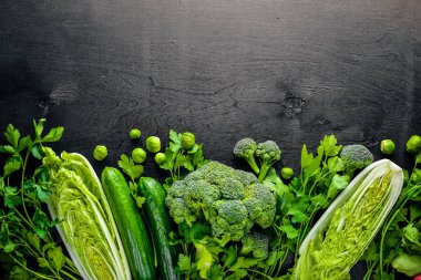 Kara taş üzerine yerleştirilmiş taze yeşil sebze topluluğu