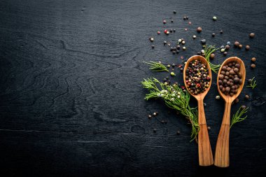 Güzel kokulu baharatlar kümesi. Siyah ve kırmızı biber, kişniş, kırmızı biber karışımı. Ahşap arka plan üzerinde. Üstten Görünüm. Boş alan.