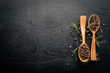 Güzel kokulu baharatlar kümesi. Siyah ve kırmızı biber, kişniş, kırmızı biber karışımı. Ahşap arka plan üzerinde. Üstten Görünüm. Boş alan.