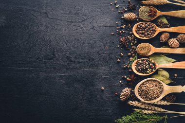 Güzel kokulu baharatlar kümesi. Siyah ve kırmızı biber, kişniş, kırmızı biber karışımı. Ahşap arka plan üzerinde. Üstten Görünüm. Boş alan.