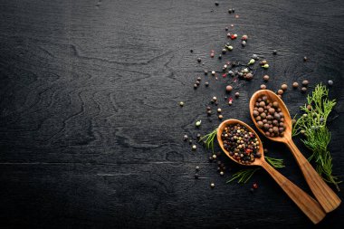 Güzel kokulu baharatlar kümesi. Siyah ve kırmızı biber, kişniş, kırmızı biber karışımı. Ahşap arka plan üzerinde. Üstten Görünüm. Boş alan.