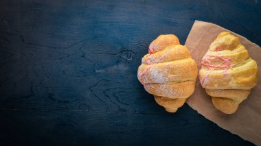 Yoğurtlu kruvasan. Böreği hamur. Siyah ahşap arka plan üzerinde. Metin için özgür yer. Üstten Görünüm,