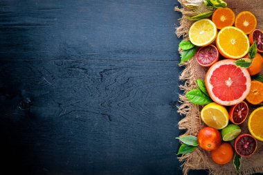 Taze narenciye. Limon portakal, mandalina, limon. Bir siyah arka plan üzerine tahta. Üstten Görünüm.