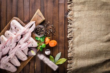 Baharat ile çiğ tavuk kanatları. Ahşap yüzeyde. Üstten Görünüm.