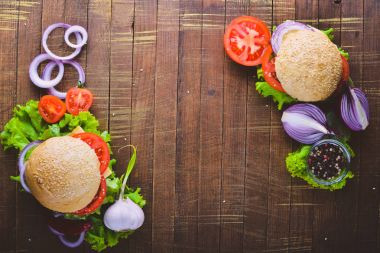 Peynir, et, domates ve soğan ve otlar ile hamburger. Ahşap arka plan üzerinde. Üstten Görünüm. Boş alan.