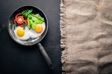 Sahanda yumurta ile bir tavada sebze ve otlar. Üstten Görünüm. Boş alan.