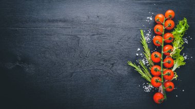 Kiraz domates ve sebze. Ahşap bir arka plan üzerinde. Üstten Görünüm. Metin için boş alan.